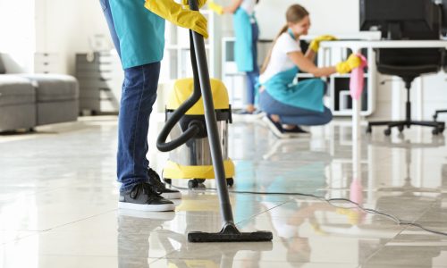 Janitor hoovering floor in office